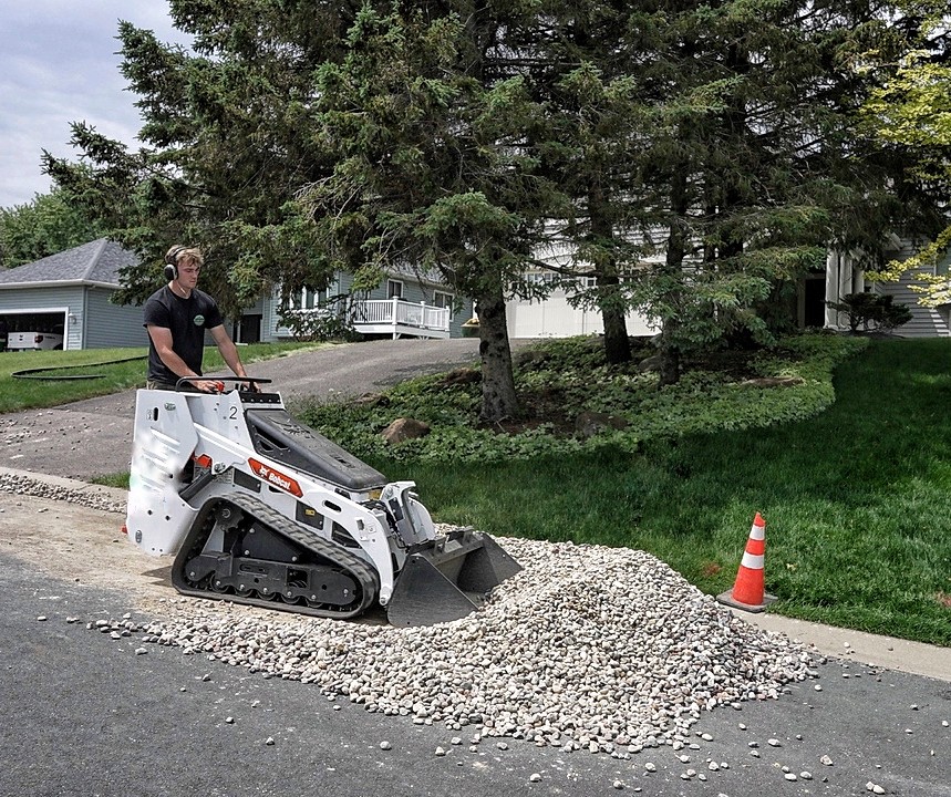 Professional landscapers laying weed barrier and rock